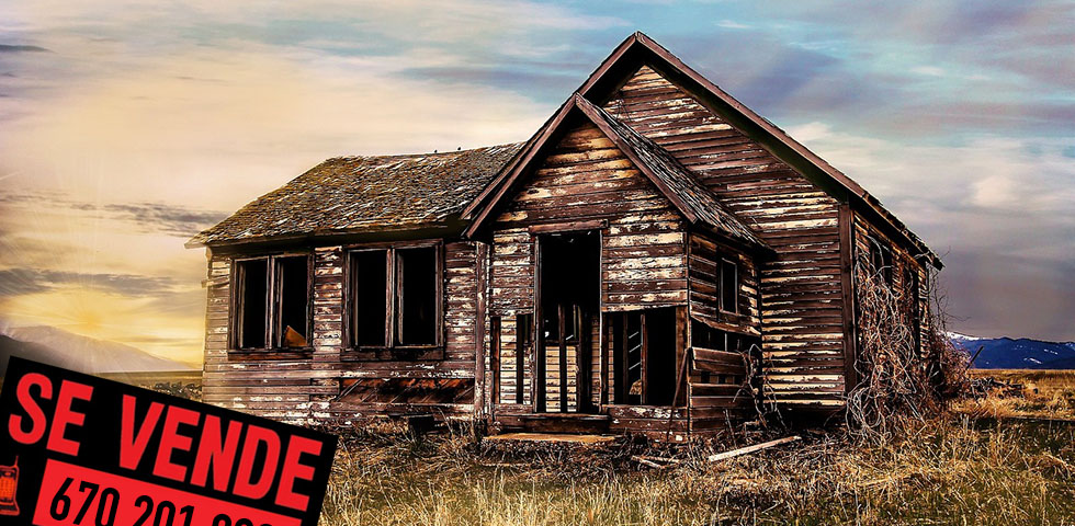 Foto de una casa de pueblo barata en ruinas con un cartel de venta